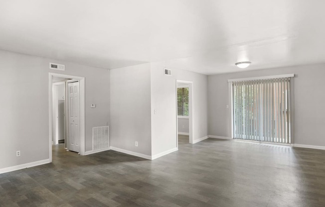 the living room and dining room of an empty house with white walls