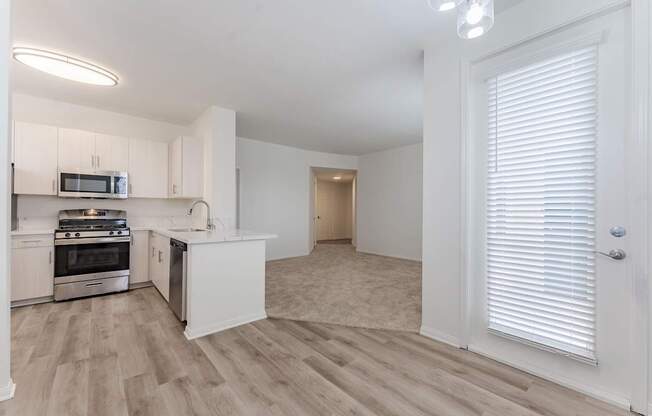 A kitchen with white cabinets and a microwave above the stove.