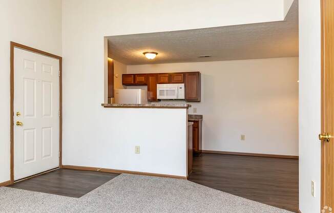 A kitchen area with a white door and a white wall.