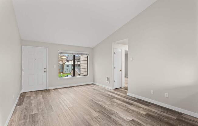 A room with wooden flooring and white walls.