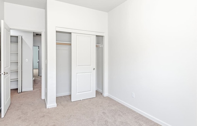 A white room with a carpeted floor and two white doors at The Landing Apartments and Townhomes, Oregon, 97045