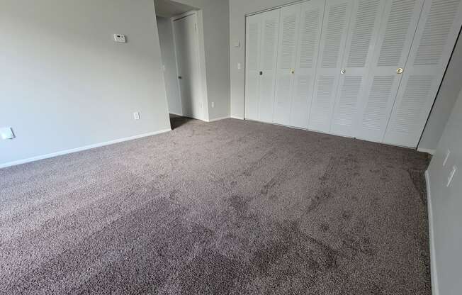 Spacious living room with large coat closets at Garfield Commons Apartments in Clinton Township, Michigan