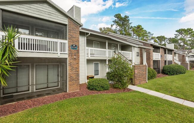 an apartment building with balconies and a grass yard