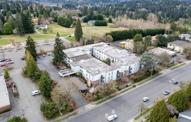 an aerial view of a building with trees and a street