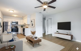 A modern living room with a grey couch, a wooden coffee table, and a flat screen TV.