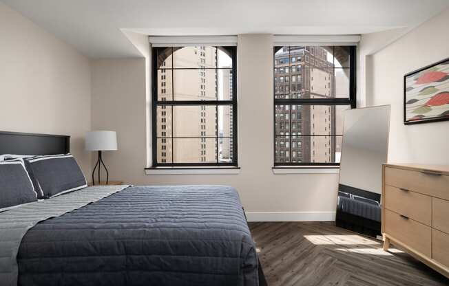 a bedroom with a bed and two windows