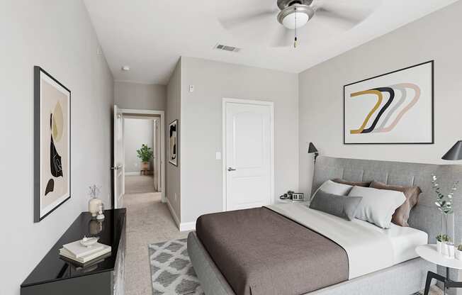 A bedroom with a large bed and a ceiling fan.