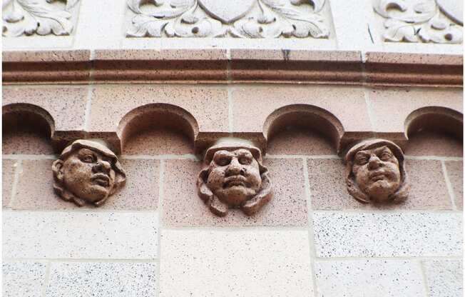 three faces on the side of a building