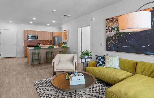 A modern living room with a yellow couch and a coffee table.