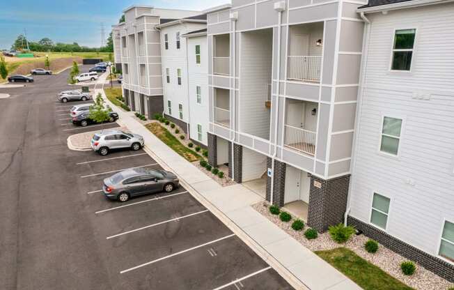 an aerial view of an apartment building with cars parked in a parking lot