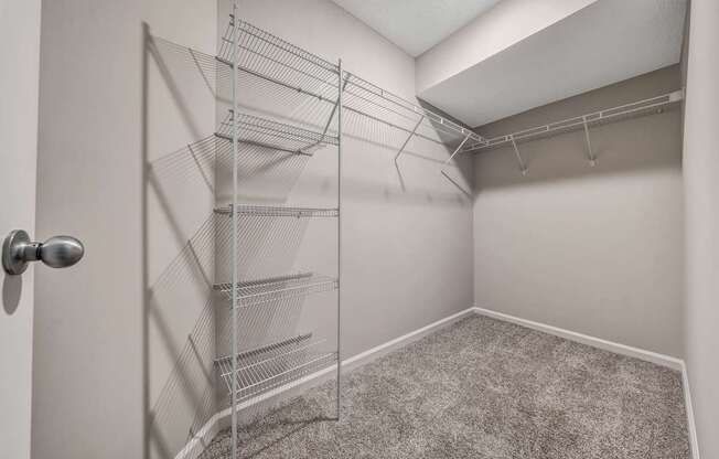 A room with a carpeted floor and a door with a handle.