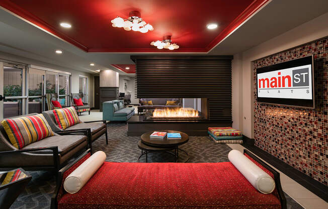 A living room with a red couch and a fireplace.