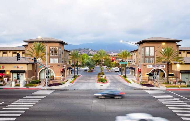 A street view of a town with a car driving down the road.