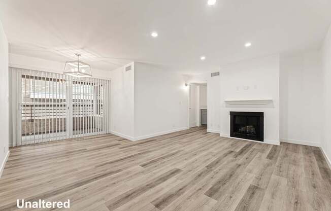 A spacious living room with a fireplace and a sliding door.