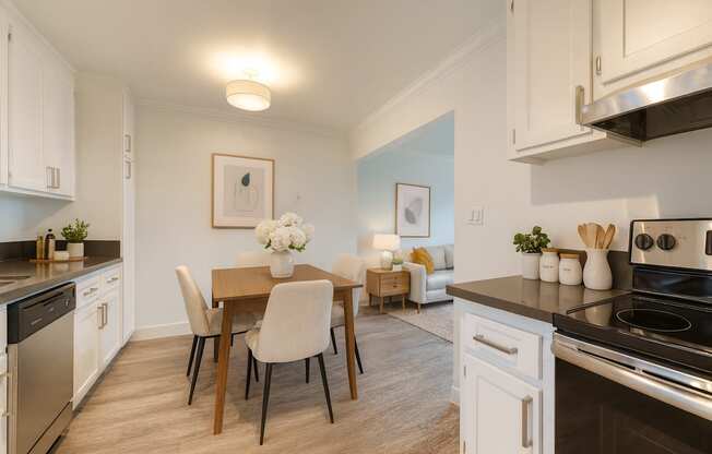 A kitchen with a dining table and chairs.
