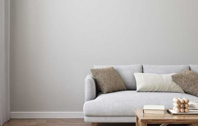 a living room with a white couch and a wooden coffee table in front of a gray wall