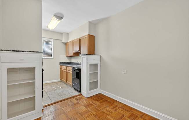 A kitchen with a black counter top and wooden cabinets.
