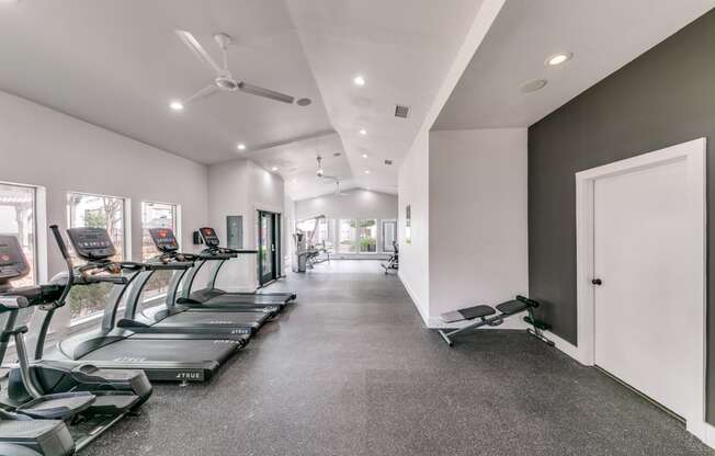 the gym has cardio equipment and treadmills on the floor