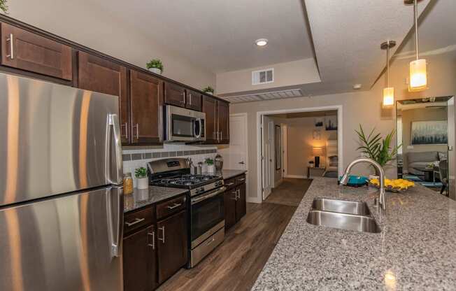 Kitchen with wooden cabinets and steel appliances at Level 25 at Cactus by Picerne, Las Vegas, NV, 89141