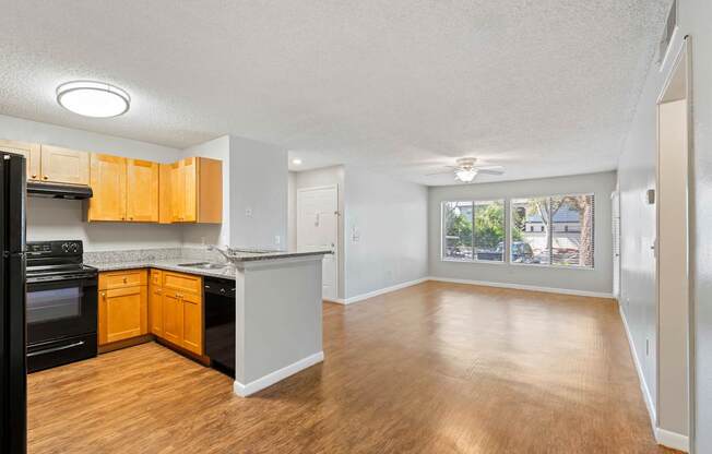 Model view of kitchen counter and living room with wood flooring at Huntington Place in Sarasota, Florida.