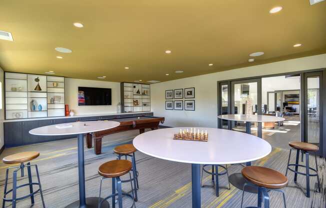 Community Clubhouse Game Room with Round Desk, Stools, Chess Set, Mounted Flatscreen Television 