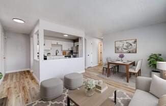 A modern living room with a kitchen in the background at The Hampton Meadows Apartments, IA,50315