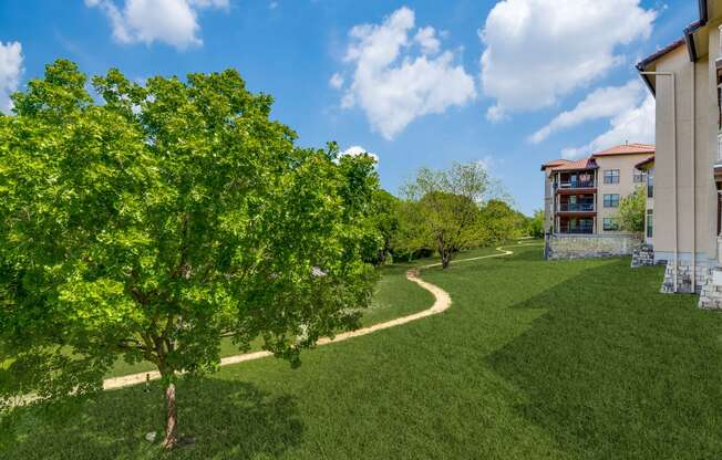 a path through the grass next to a building