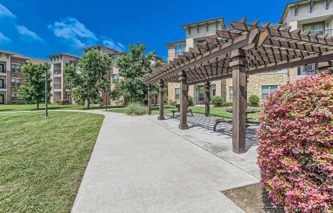 a walkway with a pergola and benches in front of an apartment building at Discovery at Craig Ranch, McKinney, TX, 75070