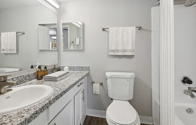 Model Bathroom with Wood-Style Flooring at Hilands Apartments in Tucson, AZ.