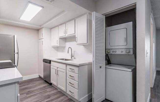 A kitchen with white cabinets and appliances.