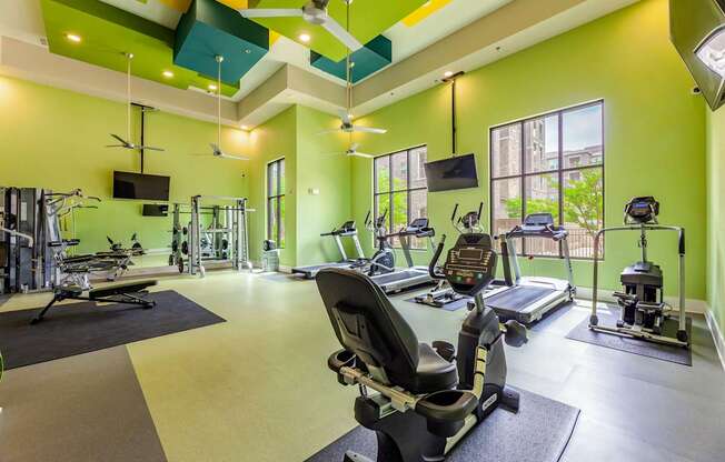 A gym with a green wall and a treadmill.