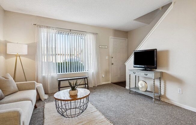 an empty living room with a couch and a tv