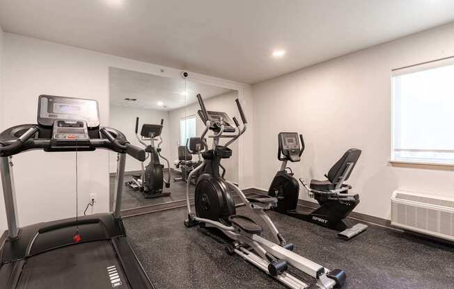 A well-equipped gym with treadmills, elliptical machines, and other exercise equipment.