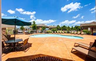 our apartments have a large pool and patio with chairs and umbrellas