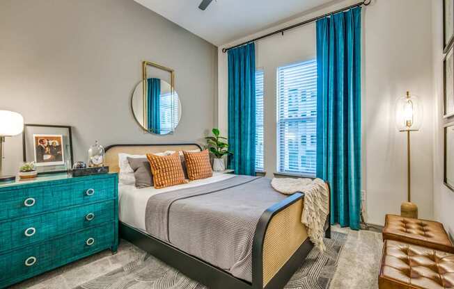 A bedroom with a bed, dresser, and mirror.