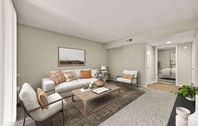 the living room of an apartment with a couch and a table at Legacy Apartments in Plano, TX