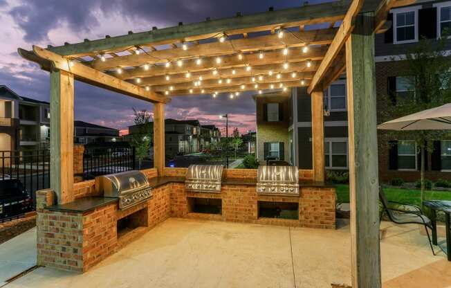a brick patio with a pergola with lights on it