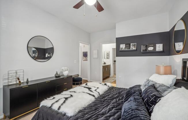 a bedroom with a black and white bed and a mirror