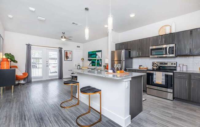 A kitchen with a bar stool in front of a counter.