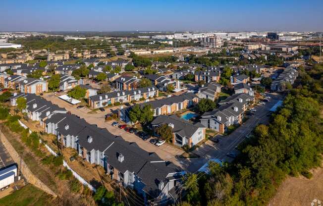 an aerial view of a neighborhood with houses and a city in the background at Water Ridge, Texas, 75061