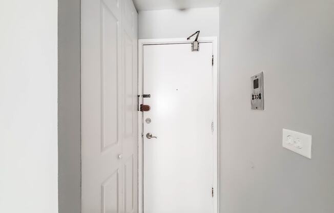 a white door in a room with a wooden floor and grey walls