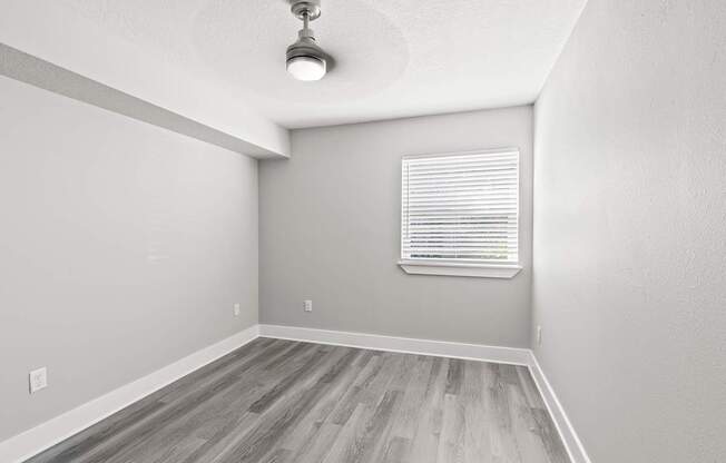A room with a window and wooden flooring.