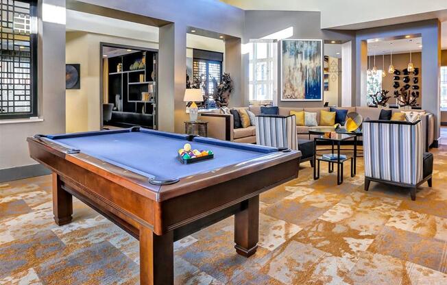a large living room with a pool table in the middle of it