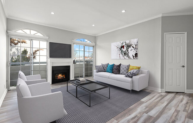 Large living room featuring hardwood floors and natural light providing adjacent patio.