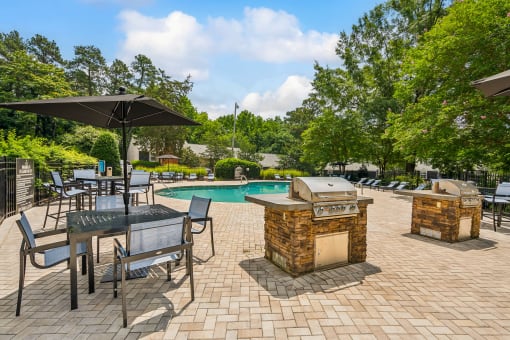 a backyard with a swimming pool and tables with umbrellas