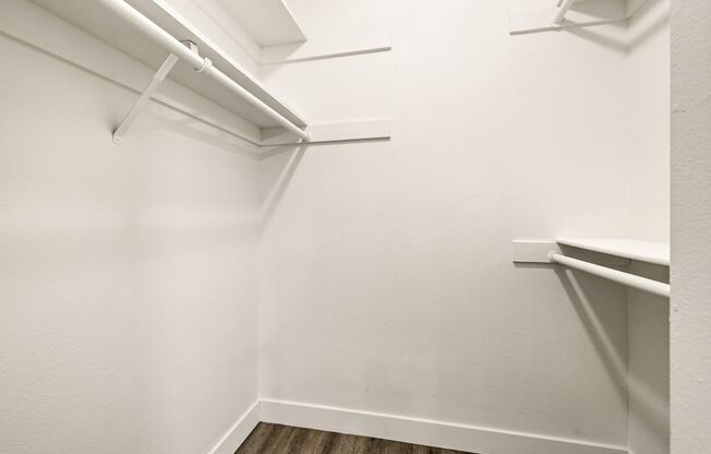 A white closet with a white shelf and a white wall.