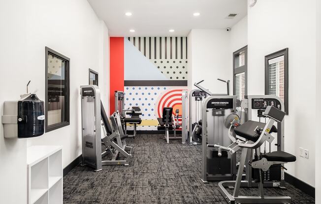 a gym with cardio machines and other exercise equipment in a room with white walls