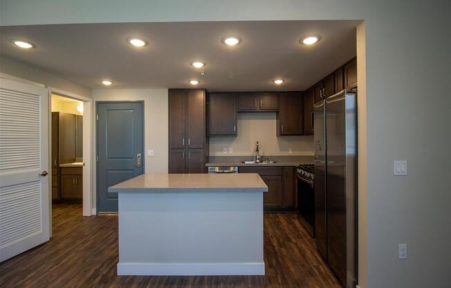 a kitchen with a center island next to a stove top oven at Loma Villas Apartments, San Bernardino California