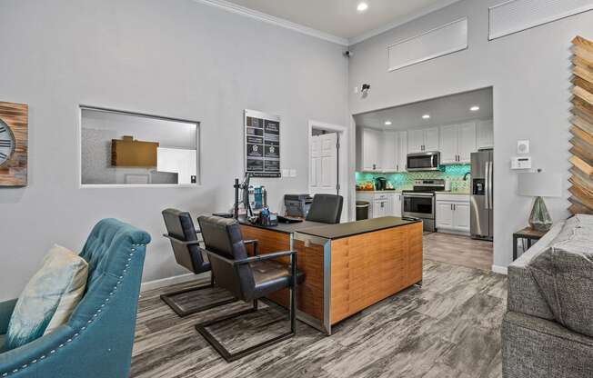 a kitchen and living room with a desk and chairs