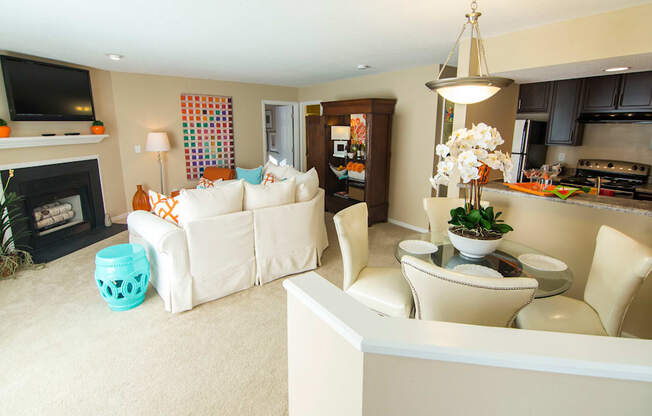 A living room with a white couch and a fireplace.